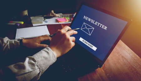 Newsletter concept hand of businessman checking message box on digital laptop vintage tone filter