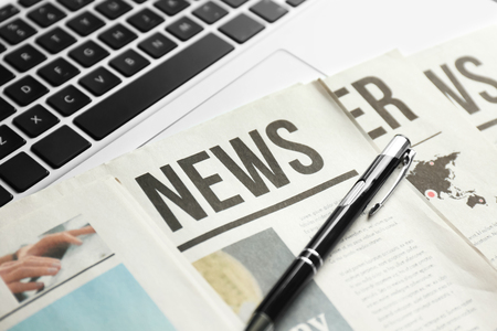 Newspaper pen and laptop closeup Stock Photo