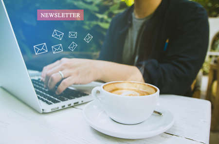 Newsletter concept hand of businessman or designer checking message box on digital laptop blank black space for your text