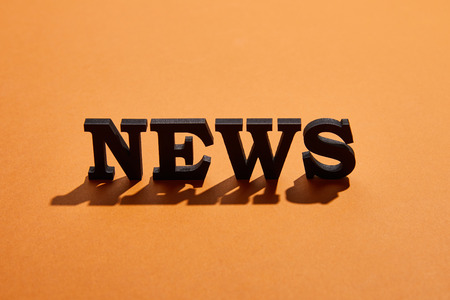 News lettering with shadows and copy space on orange