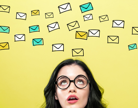 Many emails with young woman wearing eye glasses Stock Photo