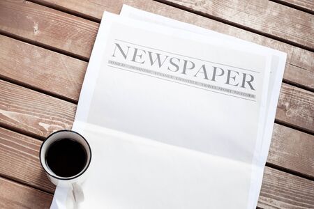Newspaper and coffee on wooden background
