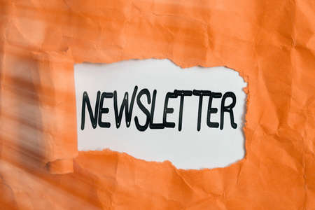 Conceptual hand writing showing newsletter concept meaning the bulletin was given to members of a company regularly rolled ripped torn cardboard above a wooden classic table