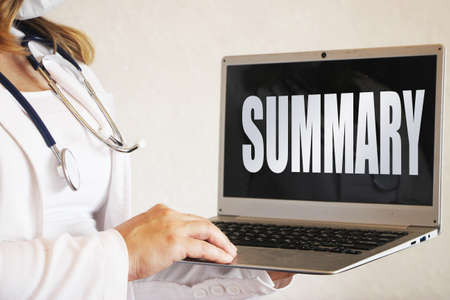 Female doctor holding laptop showing word summary on black healthcare concept