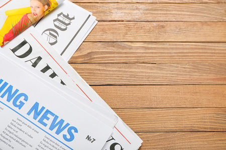 Newspapers on wooden background closeup