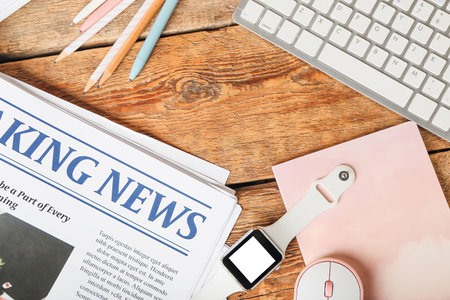 Composition with newspaper and smartwatch on wooden background