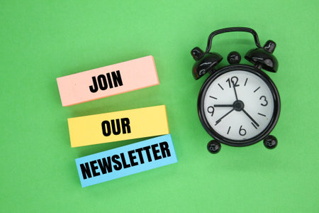 Bell clock and colored paper with the words join our newsletter business marketing concept