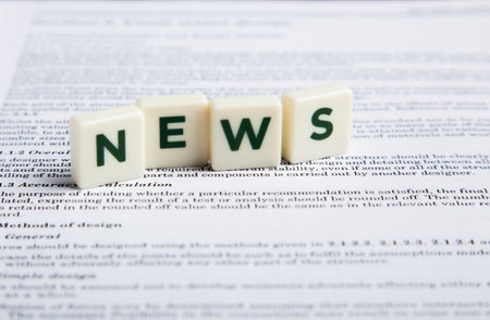The word news on cubes on a newspaper concept for breaking news Stock Photo