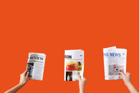 Women with newspapers on orange background Stock Photo