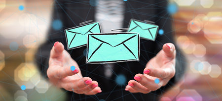 Email concept above the hands of a woman in background
