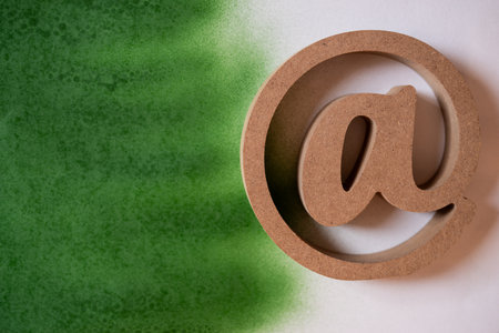 At sign on a white and green background