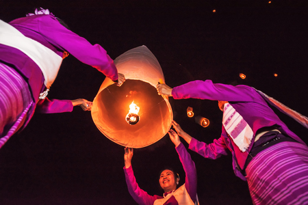 CHIANG MAI, THAILAND - NOVEMBER 13 : Unidentified women in traditional dress release floating lamp made of paper in LAMP Festival at San Kamphaeng district on November 13, 2015 in Chiangmai,Thailand.