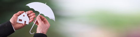 Concept of insurance with umbrella over a house