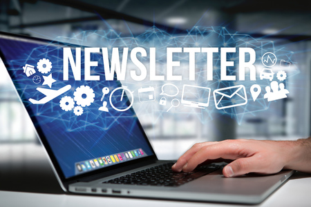 Concept view of man holding futuristic interface with newsletter title and multimedia icons flying all around internet concept
