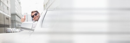 Digital composite of cool man in car with thumbs up with transition