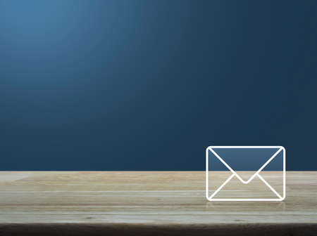 Mail icon on wooden table over light gradient blue background contact us concept